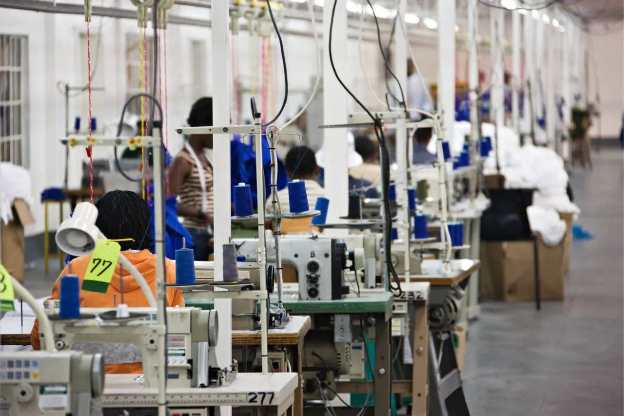 Taller de confección con máquinas de coser y operarias trabajando